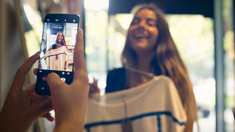 Woman smiling having her photo taken on a Samsung smartphone 