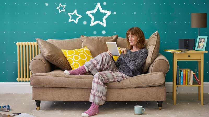 Woman relaxes on a sofa with her tablet in her living room