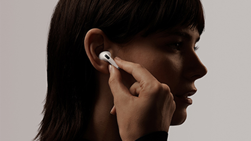  An AirPod Pro user fitting the AirPods into their ear 