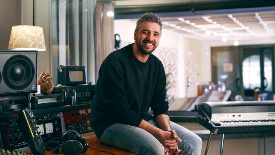 Miguel Barclay smiling, sitting in a recording studio