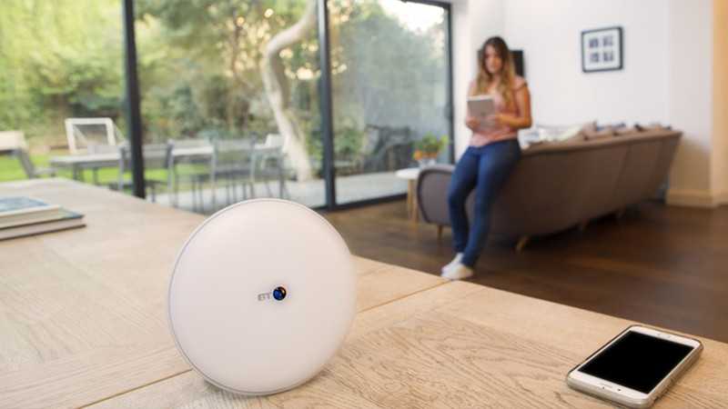 BT Whole Home Wi-Fi disc with woman using her tablet in the background