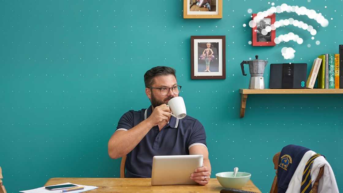 Man drinking coffee while using home broadband